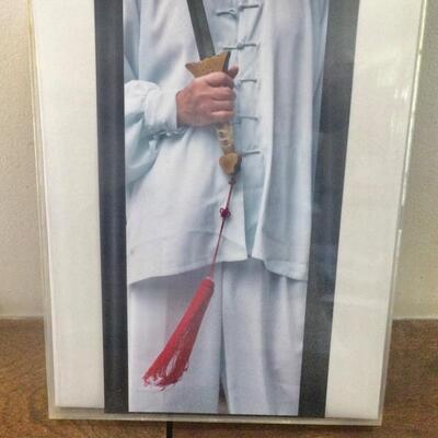 Photo framed in lucite holder, man holding sword