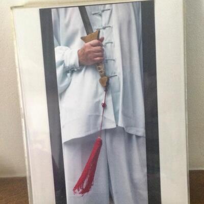Photo framed in lucite holder, man holding sword