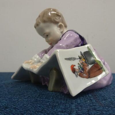 LOT 215 MEISSEN FIGURINE CHILD LOOKING AT PICTURE BOOK
