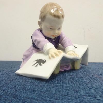 LOT 215 MEISSEN FIGURINE CHILD LOOKING AT PICTURE BOOK