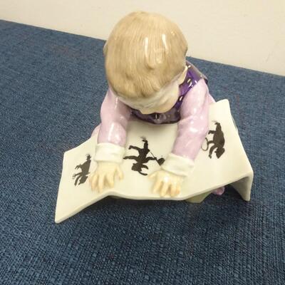 LOT 215 MEISSEN FIGURINE CHILD LOOKING AT PICTURE BOOK