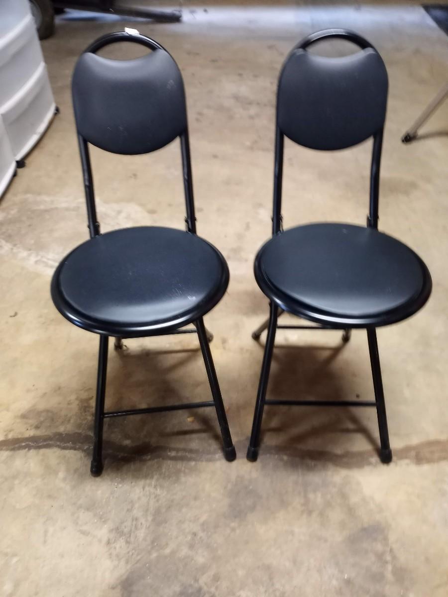 2 black small folding chairs
