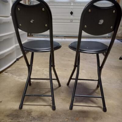 2 black small folding chairs