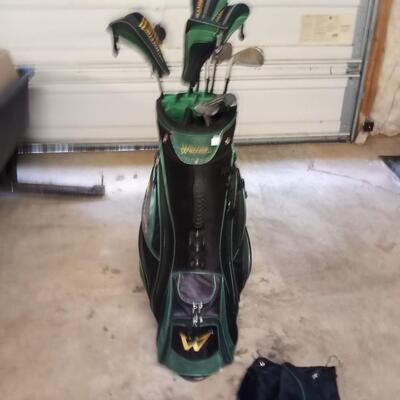 Black and green Warrior golf bag with 6 clubs and specialty tool and bag