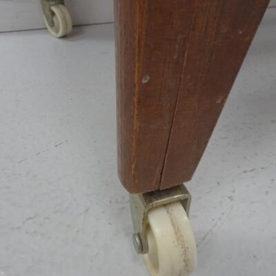 LOT 337. MCM END TABLE  WITH PLASTIC WHEELS NEEDS REPAIR