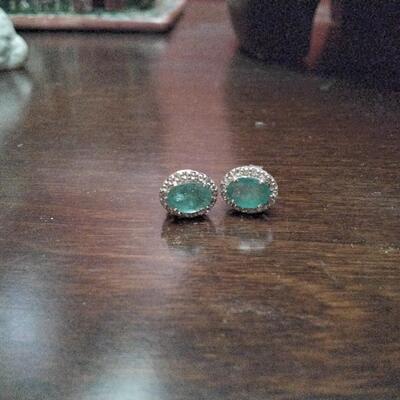 Emerald stud earrings surrounded by diamonds
