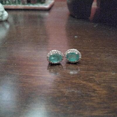 Emerald stud earrings surrounded by diamonds