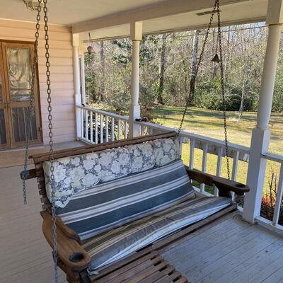 Wooden Honey Rock porch swing with foot rest and cup holders