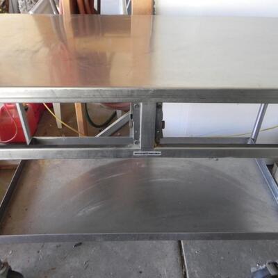 LOT 209  METAL TABLE ON CASTORS AND FURNITURE MOVER