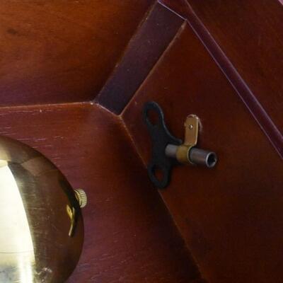 Wood  32 in tall working Grandfather clock w/key, hanging, mahogany colored wood