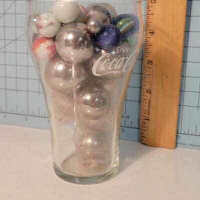 Marbles and steelies in Coca-Cola glass