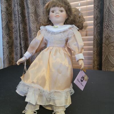 Porcelain doll in peach with stand