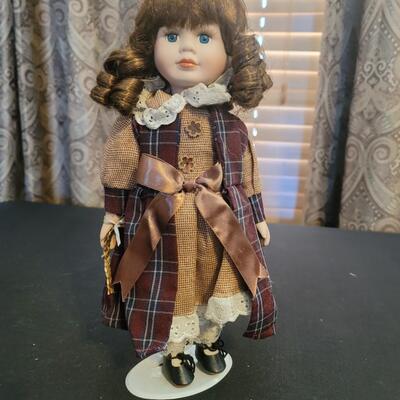 Beautiful blue eyed Porcelain doll on stand