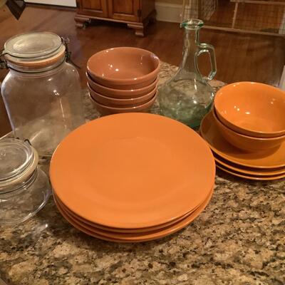 Orange plates, bowls, glass jars