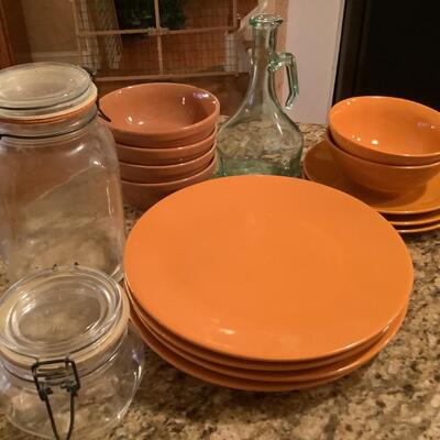 Orange plates, bowls, glass jars