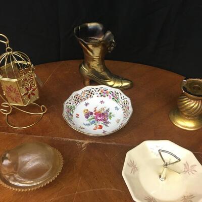 decor: bronze boot, china, hanging cage, cat on a bed, candle pedestal;