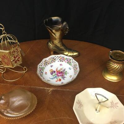 decor: bronze boot, china, hanging cage, cat on a bed, candle pedestal;