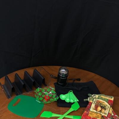 kitchen: oven mitts, measuring spoons, taco shell cooker,cutting board, various spatulas, bowl;