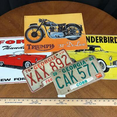 wall decor: ford, thunderbird, triumph motorcycle tags and car signage;