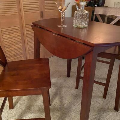 Bistro style table & chairs. Mahogany stain drop-leaf table, bar height, and two chairs