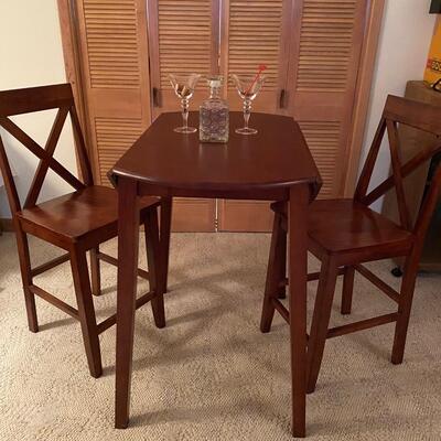 Bistro style table & chairs. Mahogany stain drop-leaf table, bar height, and two chairs