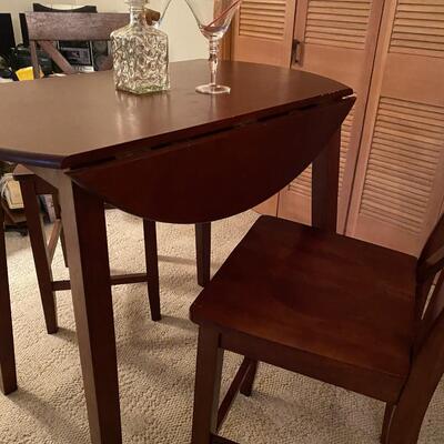 Bistro style table & chairs. Mahogany stain drop-leaf table, bar height, and two chairs