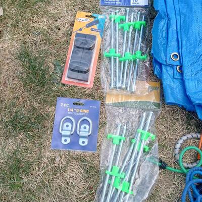 LOT 109  FIVE TARPS, BUNGEE CORDS, STAKES AND MORE