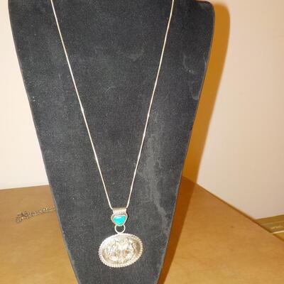 Sterling silver turquoise stone and 2 horses head design.
