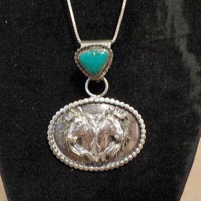 Sterling silver turquoise stone and 2 horses head design.
