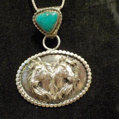 Sterling silver turquoise stone and 2 horses head design.