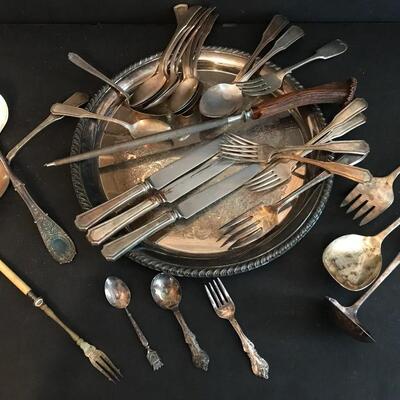 Silver plated tray with over 25 pieces of plated flatware and a horn sharpener