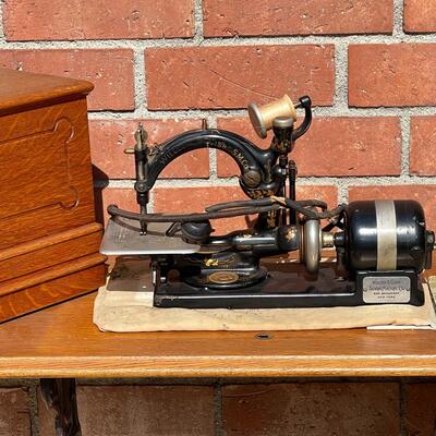 LOT 147  ANTIQUE WILLCOX & GIBBS ELECTRIC SEWING MACHINE OAK COFFIN TOP CABINET