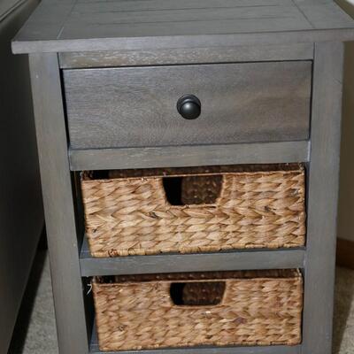 ONE DRAWER STAND WITH TWO RATTAN DRAWERS ON SHELVES BELOW IN GREY TONED WOOD