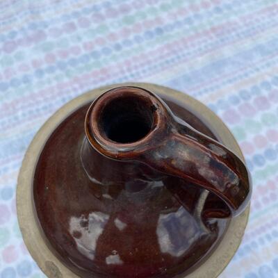 Vintage moonshine jug with brown top