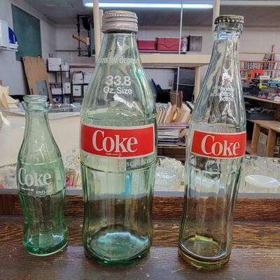 3 empty coke glass bottles