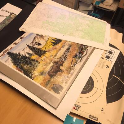 Artist Travel Bag Full of Paper targets, maps, and other wildlife items