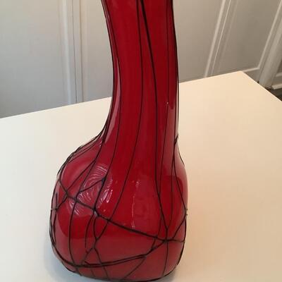 Red glass vase with white inside and strings of black glass