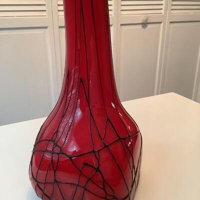 Red glass vase with white inside and strings of black glass