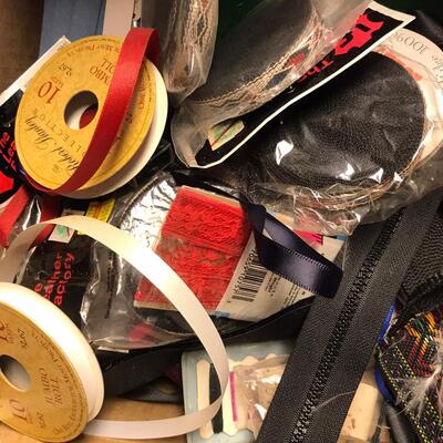 Flat of ribbon and sewing items.
