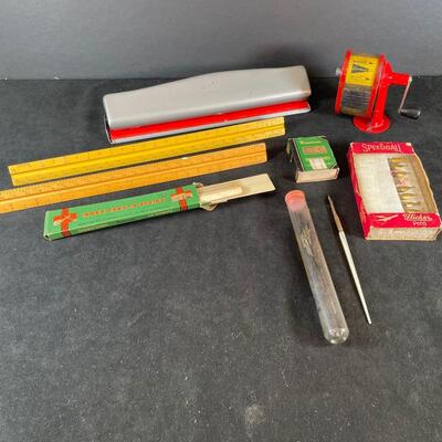 two engineering rulers
desk top pencil sharpener 
mother-of-pearl ink pen and extra pen tips
box of pen tips
3-hole punch