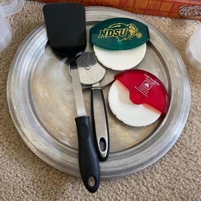 L20-Pizza stone, two metal pizza pans, utensils and plastic mugs