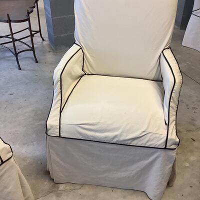 2 upholstered arm chairs with wooden legs and arms with slip covers