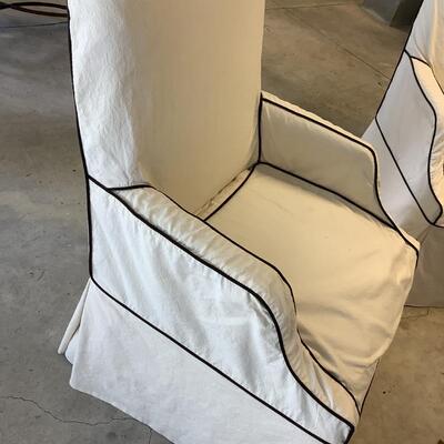 2 upholstered arm chairs with wooden legs and arms with slip covers