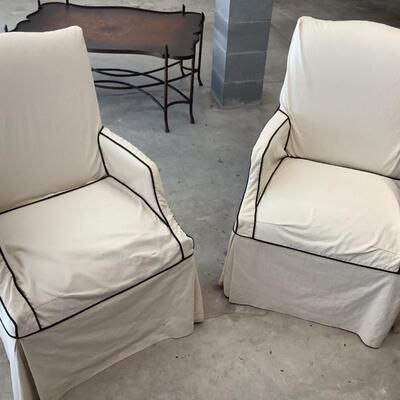 2 upholstered arm chairs with wooden legs and arms with slip covers