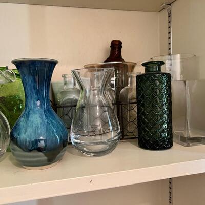 2 shelves full of glass and other materials vases