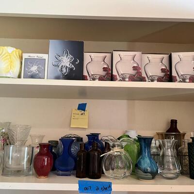 2 shelves full of glass and other materials vases
