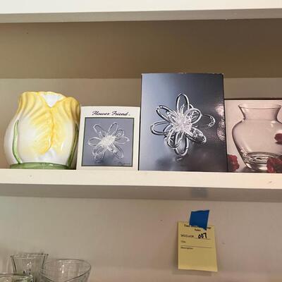 2 shelves full of glass and other materials vases