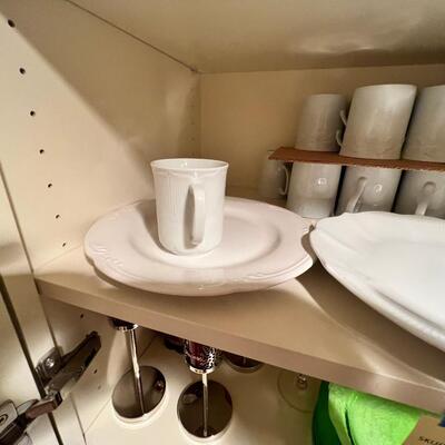 wine goblets with red swirls, green plates set white dinner plates and mugs