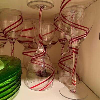 wine goblets with red swirls, green plates set white dinner plates and mugs