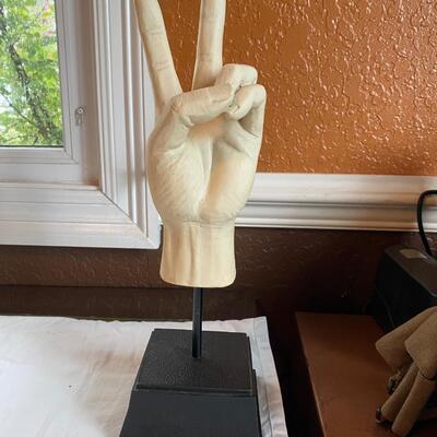 Peace sign hand sculpture on stand